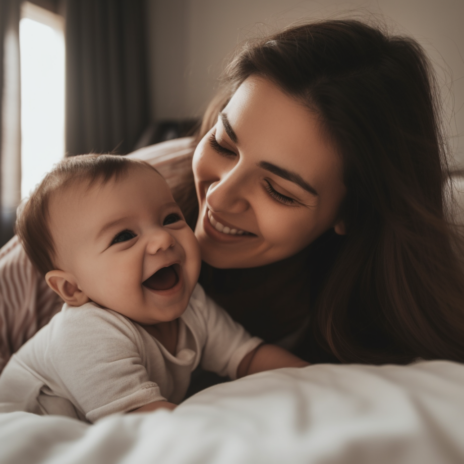 mother and baby playing on a bed
